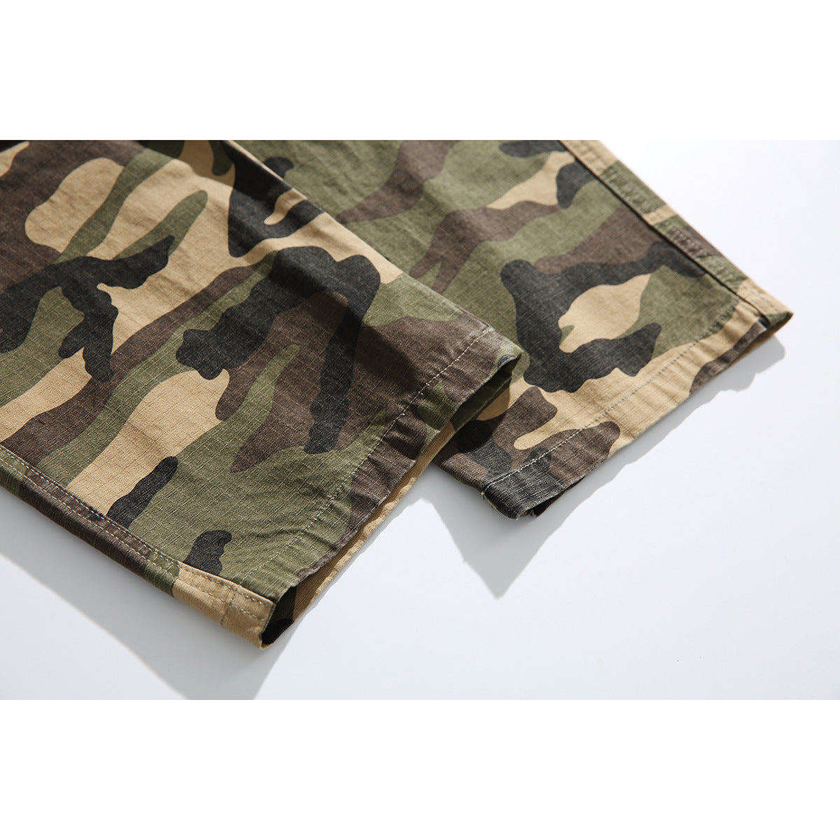 Close-up of the stitched hems and camouflage fabric on the legs of the pants.