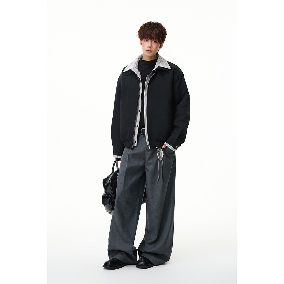 Full-length model wearing a black zip jacket with a striped collar and wide gray trousers.