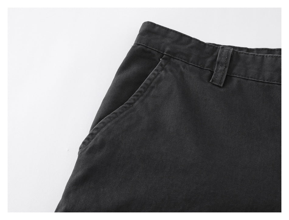 Close-up of the charcoal pants’ curved front pocket opening and waistband with a belt loop.