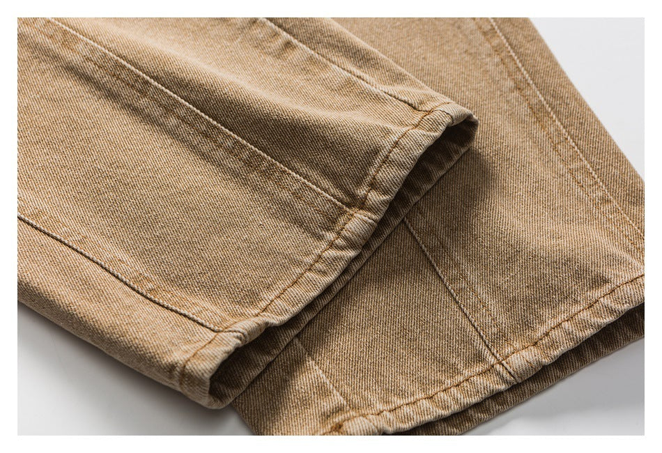Close-up of the stitched hems on folded brown pants.