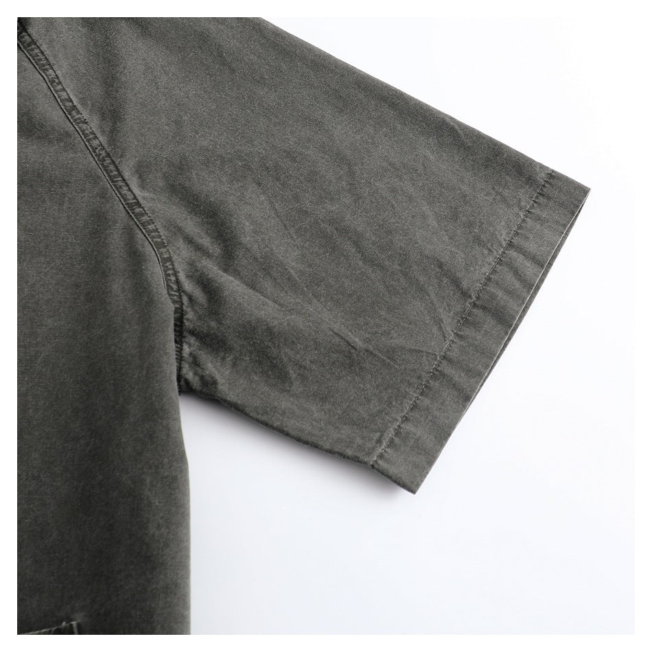 Close-up of a charcoal-gray garment's short sleeve, showing the wide hem and seam.