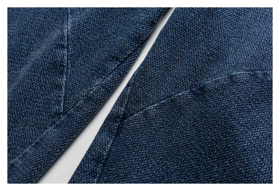 Close-up of dark blue denim showing its woven texture and a curved seam.