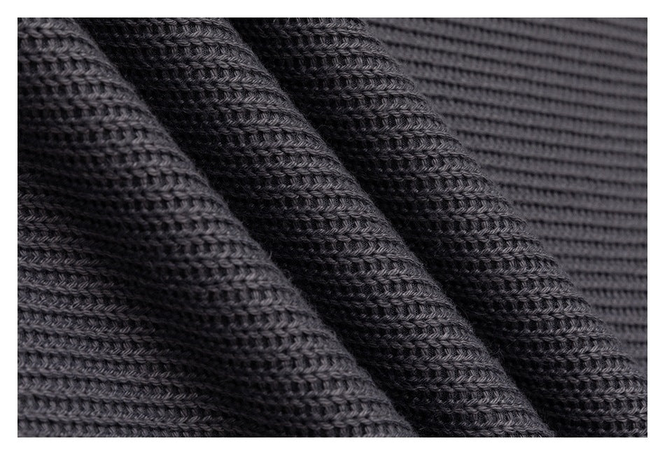 Macro view of the charcoal-gray garment’s raised knit texture and ribbed stitching.