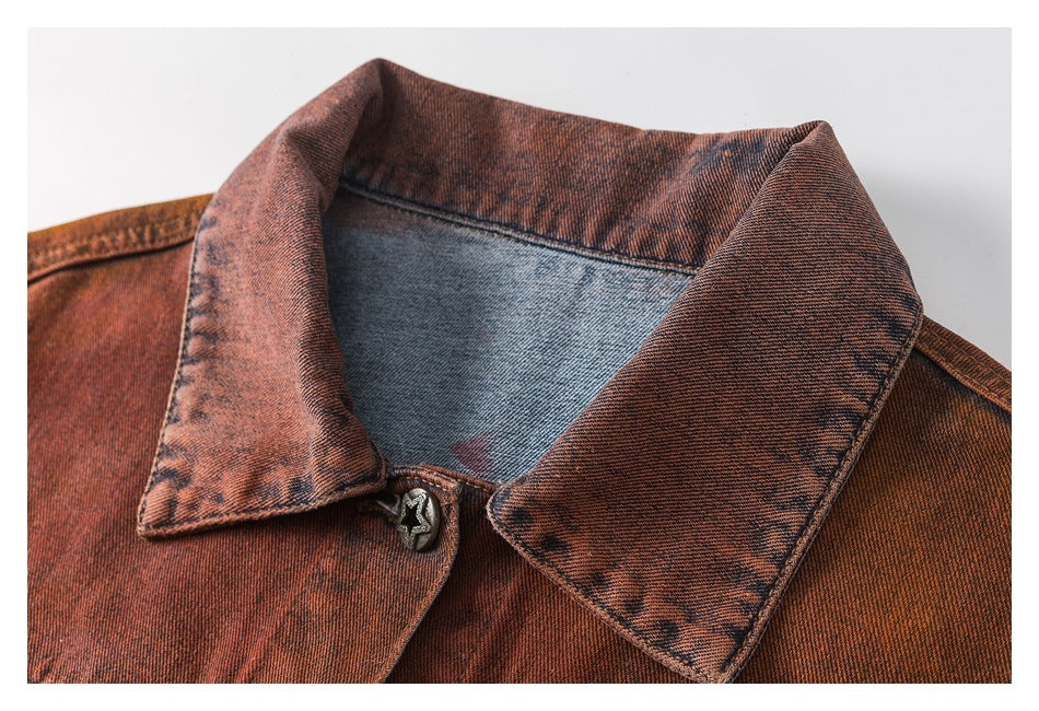Close-up of the jacket's rust denim collar, faded finish, stitching, and star-shaped top button.