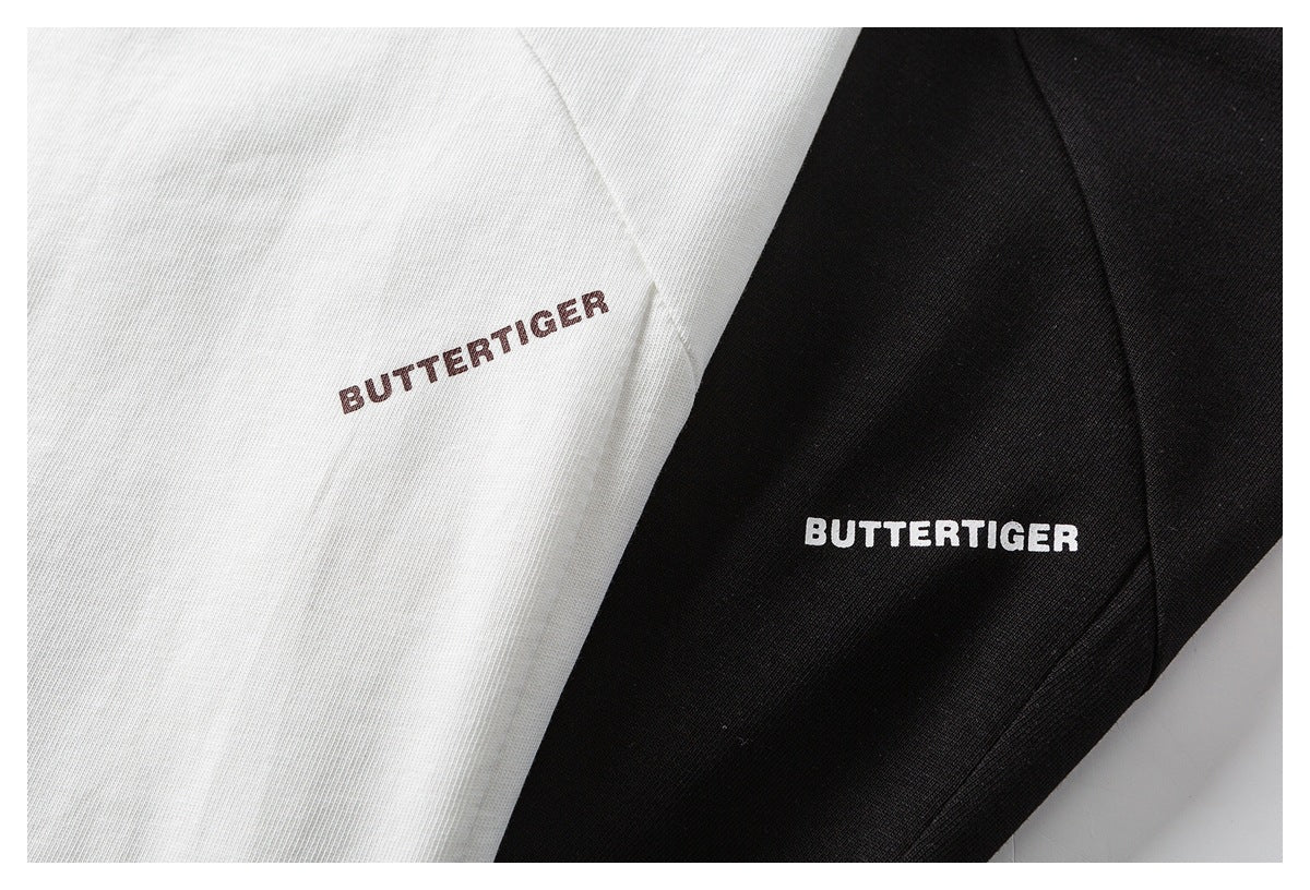 Close-up of white and black garment fabric, each printed with “BUTTERTIGER.”