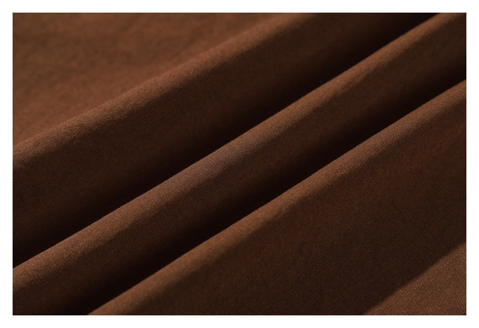 Close-up of brown garment fabric arranged in soft folds.