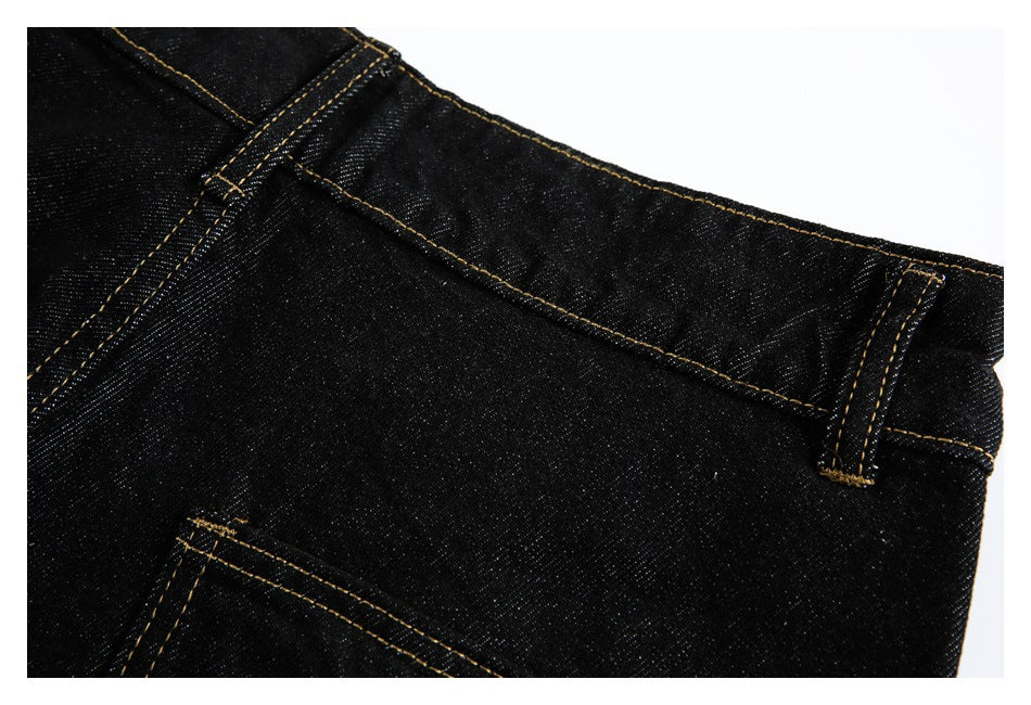 Close-up of the black jeans waistband and belt loops with golden contrast stitching.
