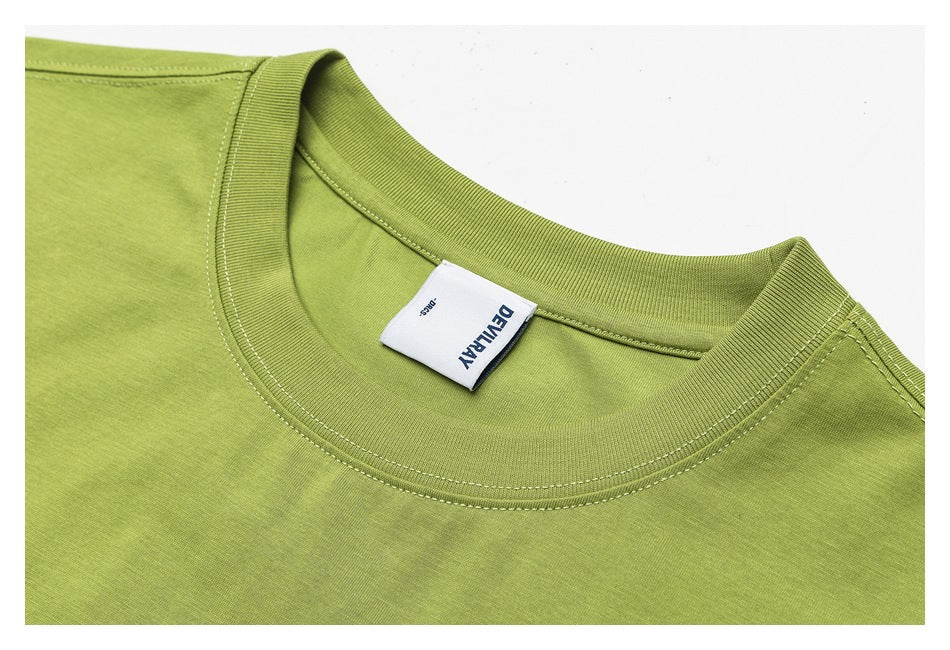 Close-up of a lime-green T-shirt crew neckline, ribbed trim, stitching, and sewn neck label.