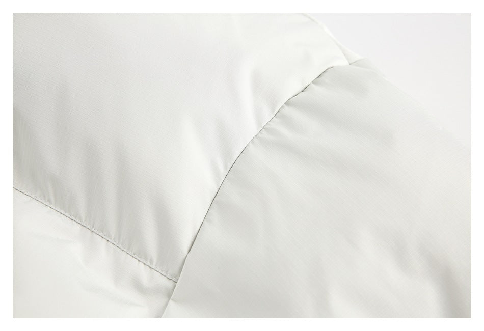 Close-up of a white jacket's shoulder and sleeve seams.