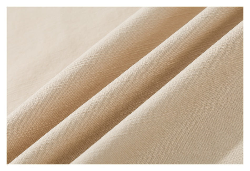 Close-up showing the fine woven texture and soft folds of beige shirt fabric.
