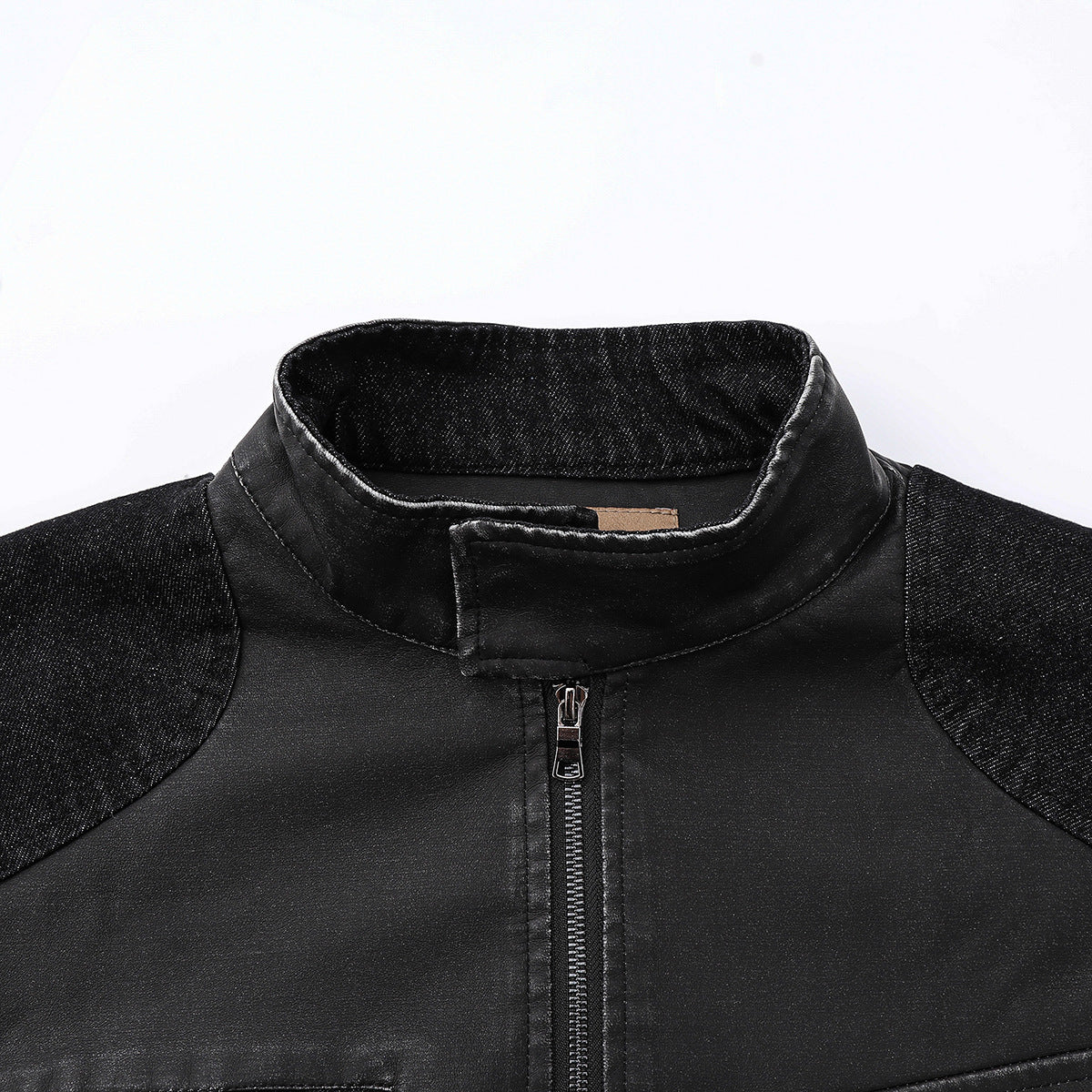 Close-up of a black jacket's stand collar, center zipper, and textured shoulder panels.
