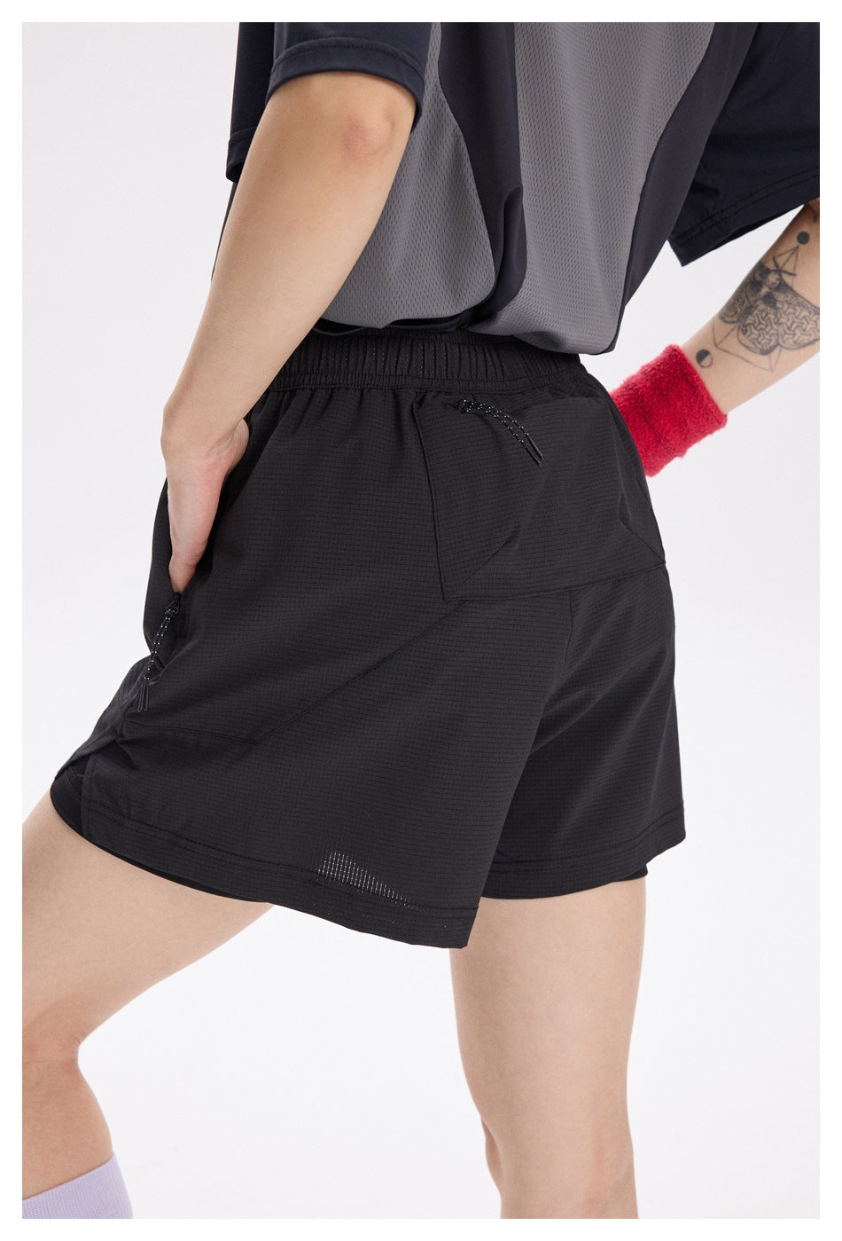 Close-up of the black shorts’ rear pockets, elastic waistband and zip closures.