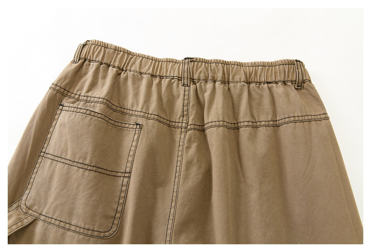 Close view of the back of tan pants, showing an elastic waistband, belt loops, and a large stitched pocket.
