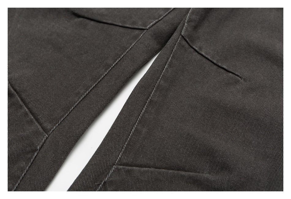 Close-up of dark charcoal pants showing a leg seam and pocket stitching.