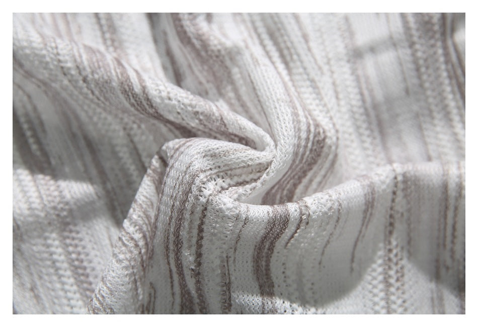 Close-up of folded off-white textured fabric with narrow gray stripes.