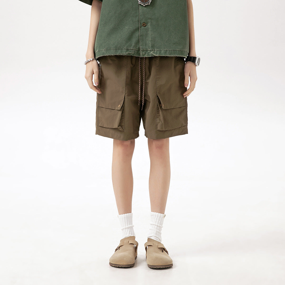 Front view of a model wearing brown cargo shorts with a drawstring waist and large flap pockets.