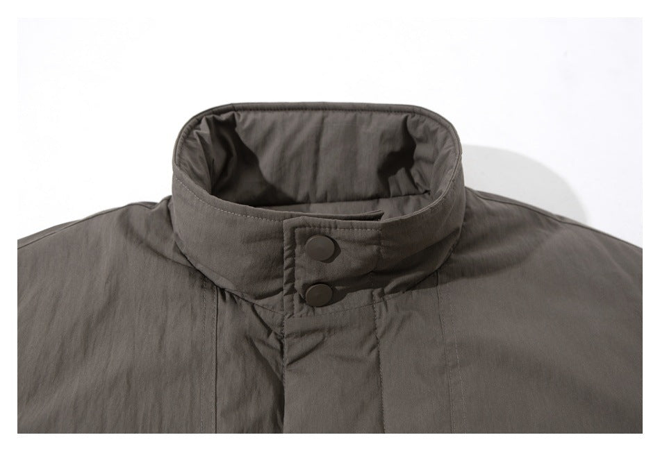Close-up of a charcoal gray jacket's stand collar and two-snap throat tab.