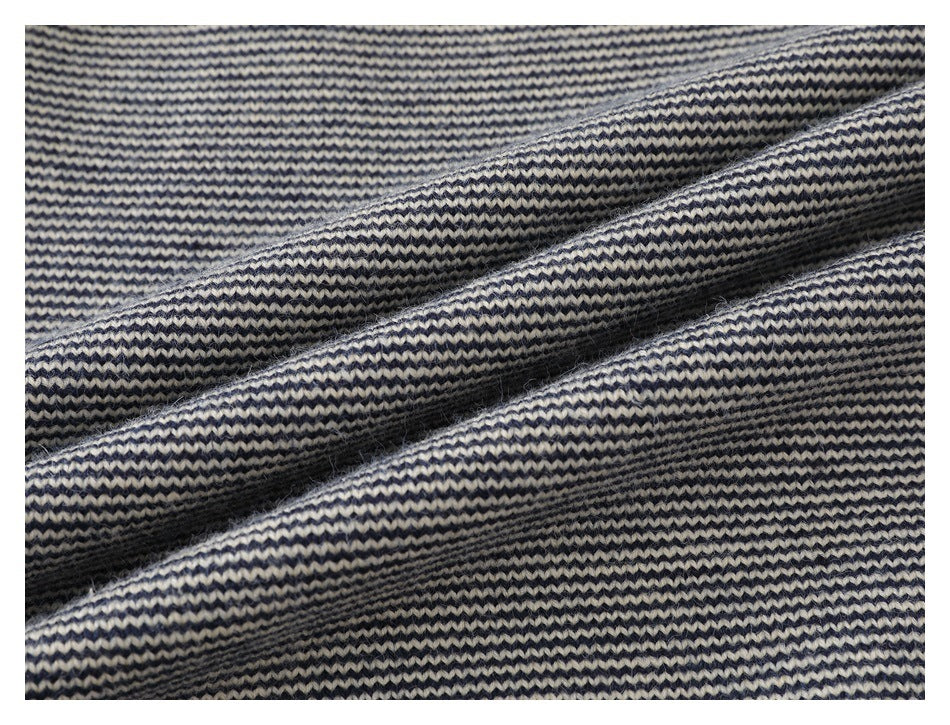 Close-up of navy and cream striped knit fabric arranged in soft folds.