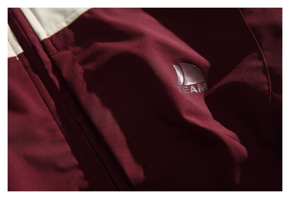 Close-up of the burgundy jacket panel with a small sail-shaped emblem and the word TEAM.