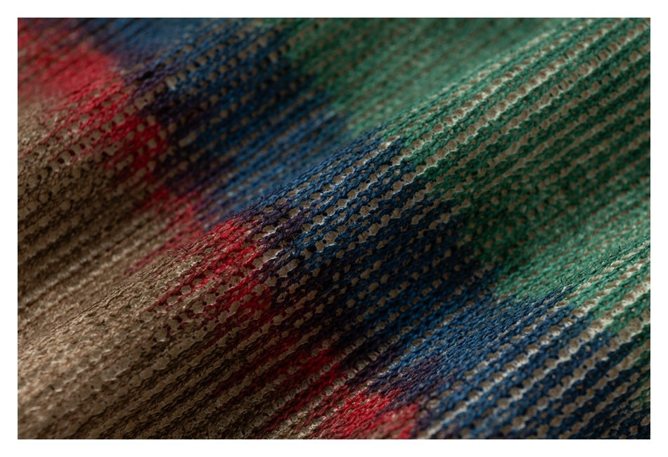 Macro view of textured knit with irregular stripes in teal, blue, red, brown, and cream.