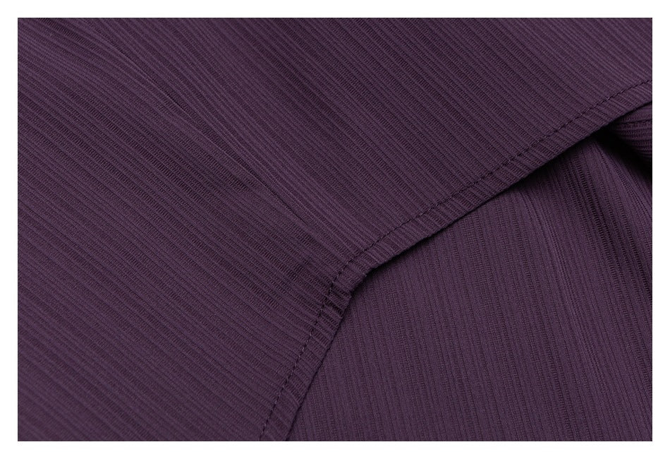 Close-up of dark plum ribbed fabric with a curved stitched seam.