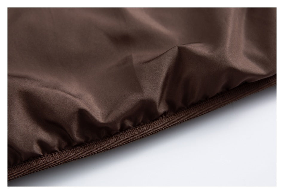 Close-up of the brown jacket hem with patterned binding along the edge.
