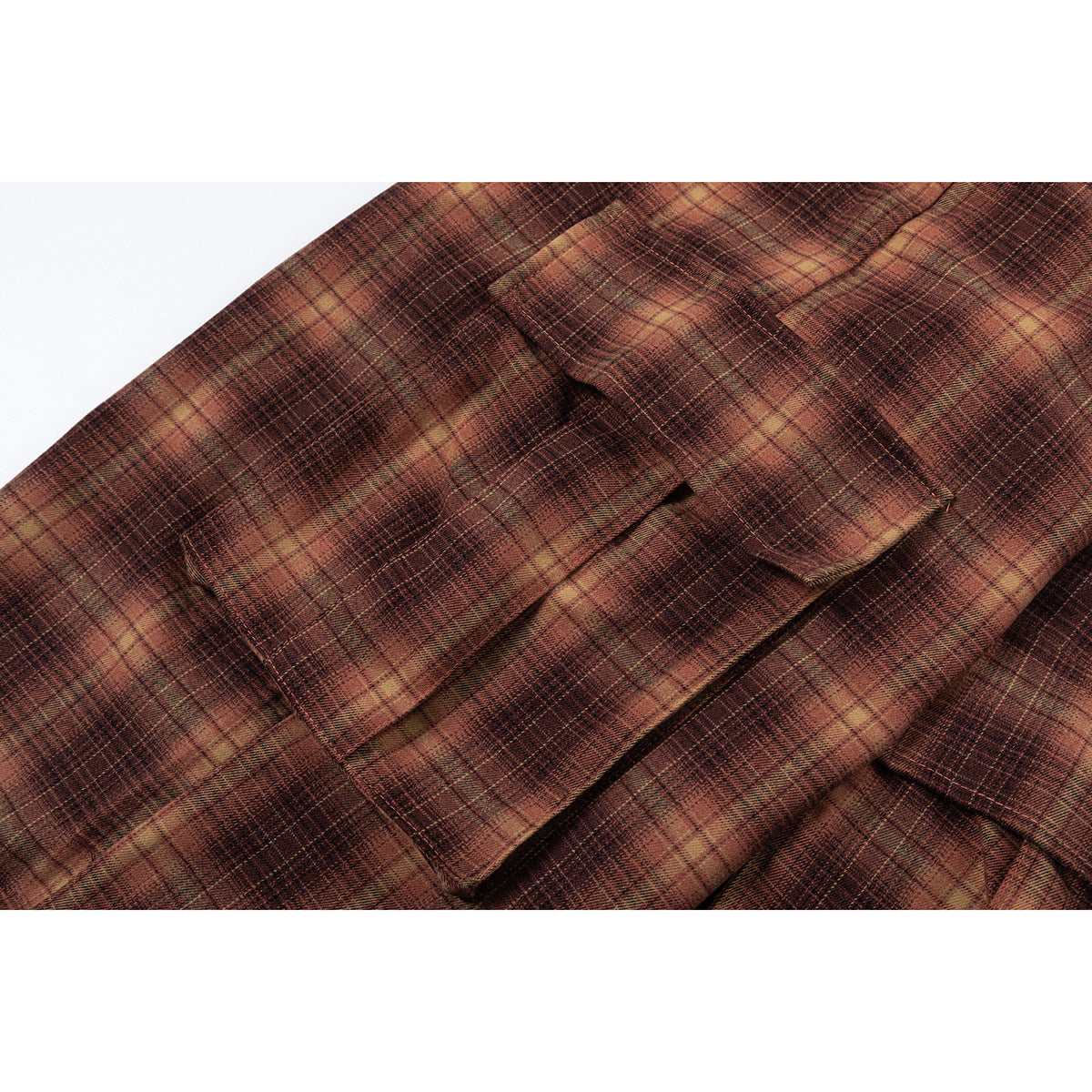 Close-up of a flap cargo pocket on brown-and-tan plaid trousers.