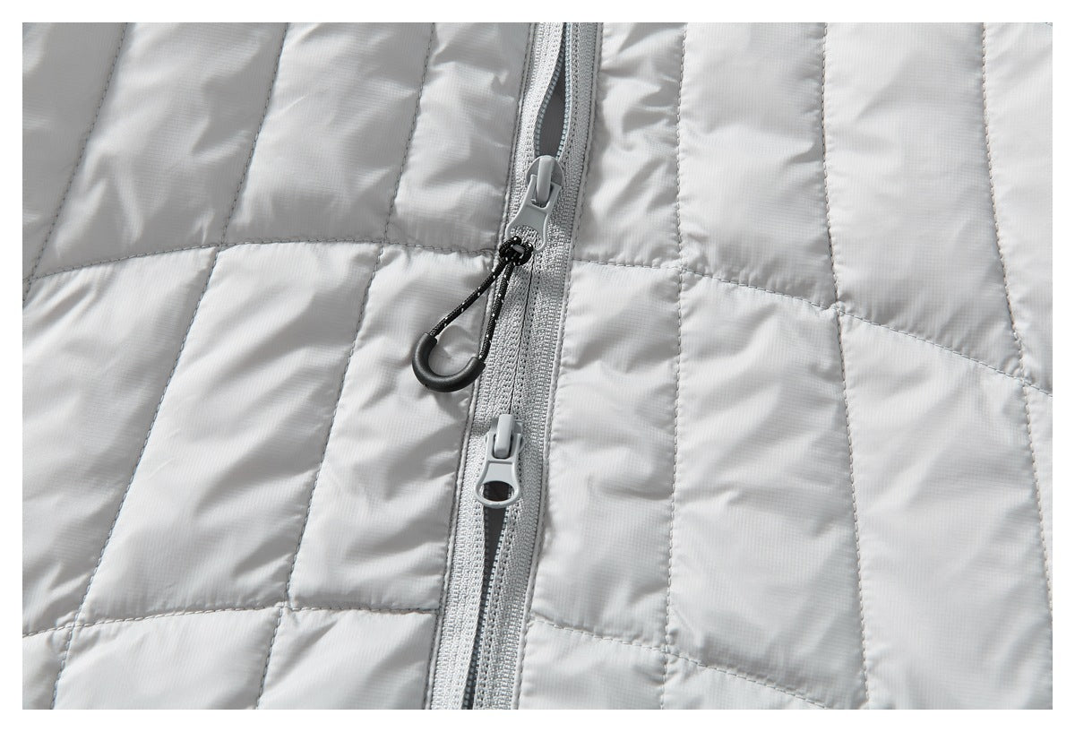 Close-up of a light gray quilted jacket's center zipper with two gray sliders and black pull loops.