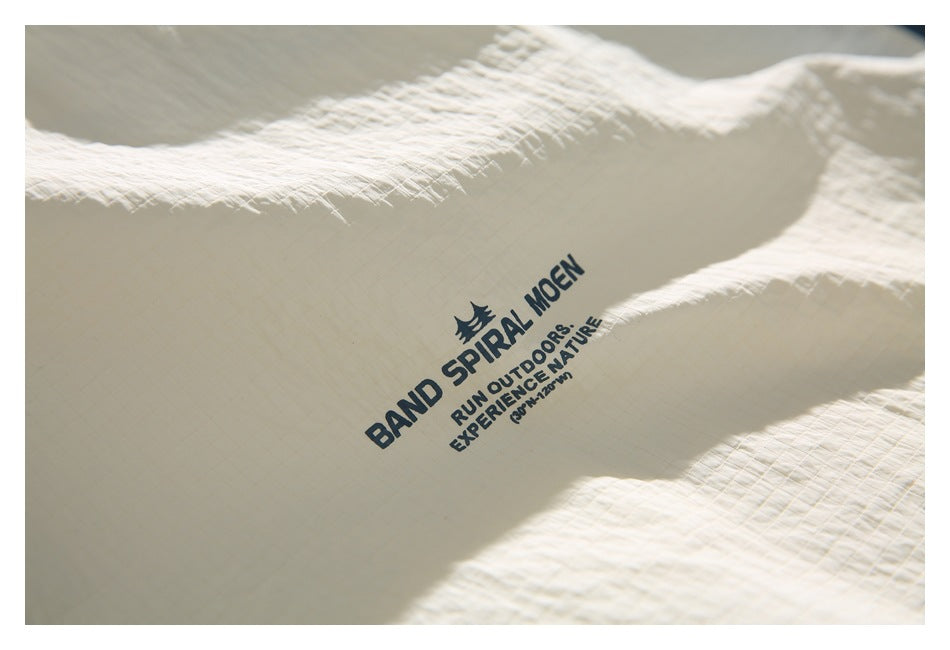 Close-up of dark printed English lettering on cream textured garment fabric.
