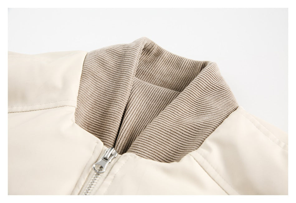 Close-up of the ivory jacket's ribbed taupe collar and front zipper.