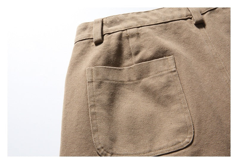Close-up of a tan trouser pocket and waistband with a belt loop.
