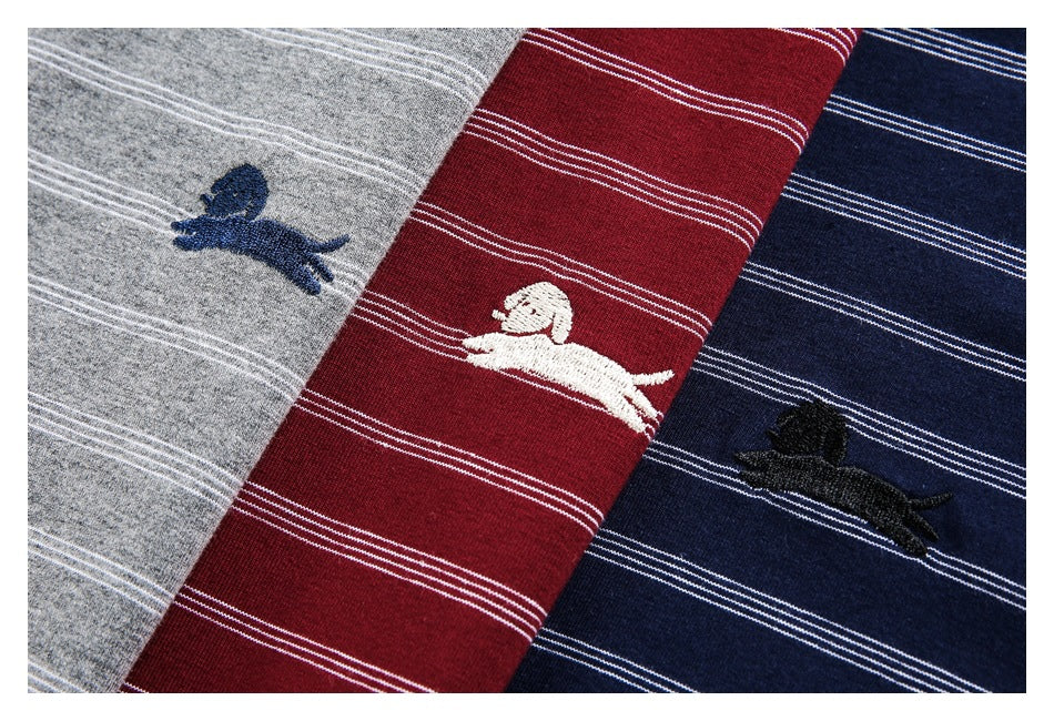 Close-up of gray, burgundy, and navy striped garments with embroidered animal motifs.