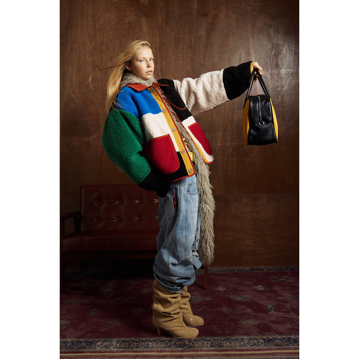 Model wearing a bright color-block button-front jacket with red pockets, baggy jeans and tan boots.