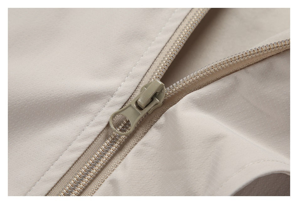 Close-up of a beige zipper and stitching on a light beige garment.