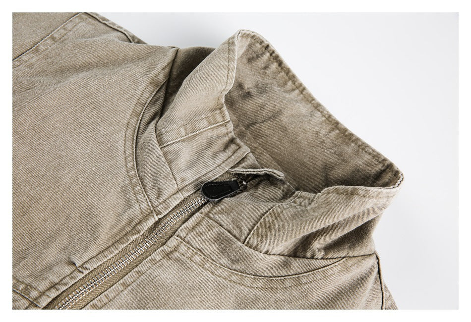 Close-up of a tan jacket's stand collar and metal front zipper.
