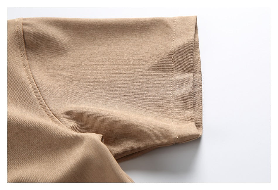 Close-up of the tan shirt sleeve, showing the short sleeve hem and stitching.