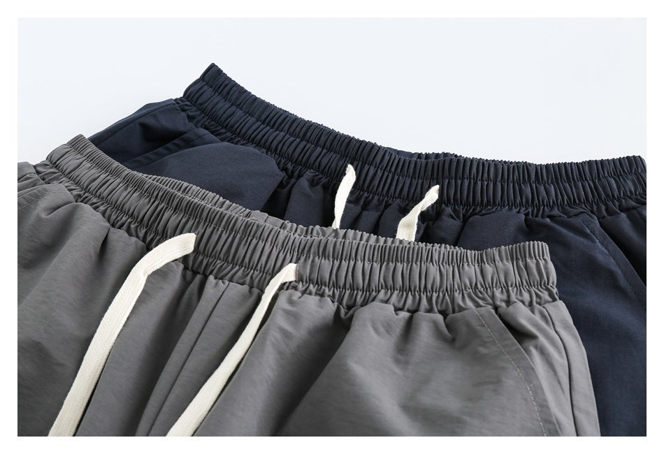 Close view of gray and navy elastic-waist bottoms with white drawstrings.