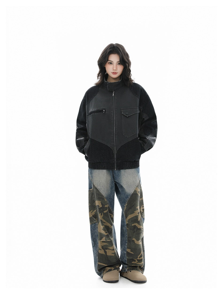 Full-length model wearing a black color-block jacket, loose blue and camouflage-panel jeans, and beige shoes.