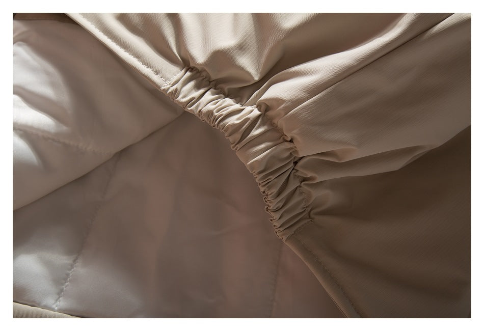 Interior close-up showing gathered elastic stitching along the beige jacket's edge.