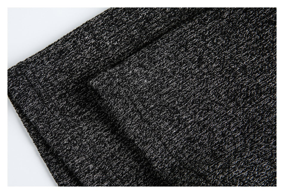 Close-up of the dark charcoal knit fabric with light gray flecks and soft folds.