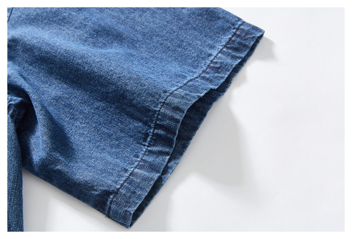 Close-up of the blue denim shirt sleeve and its stitched cuff hem.