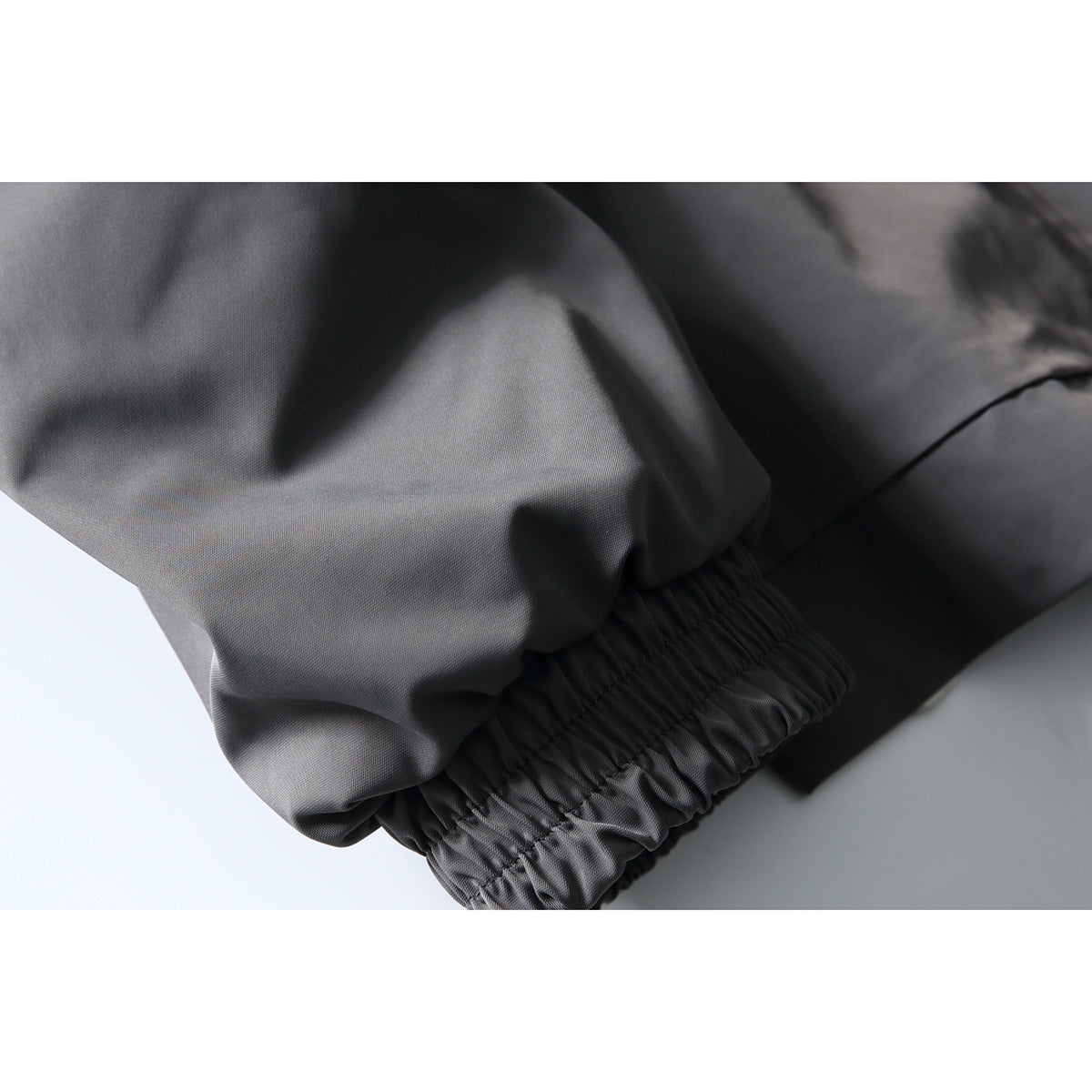 Close-up of the charcoal jacket's sleeve with a gathered elastic cuff.