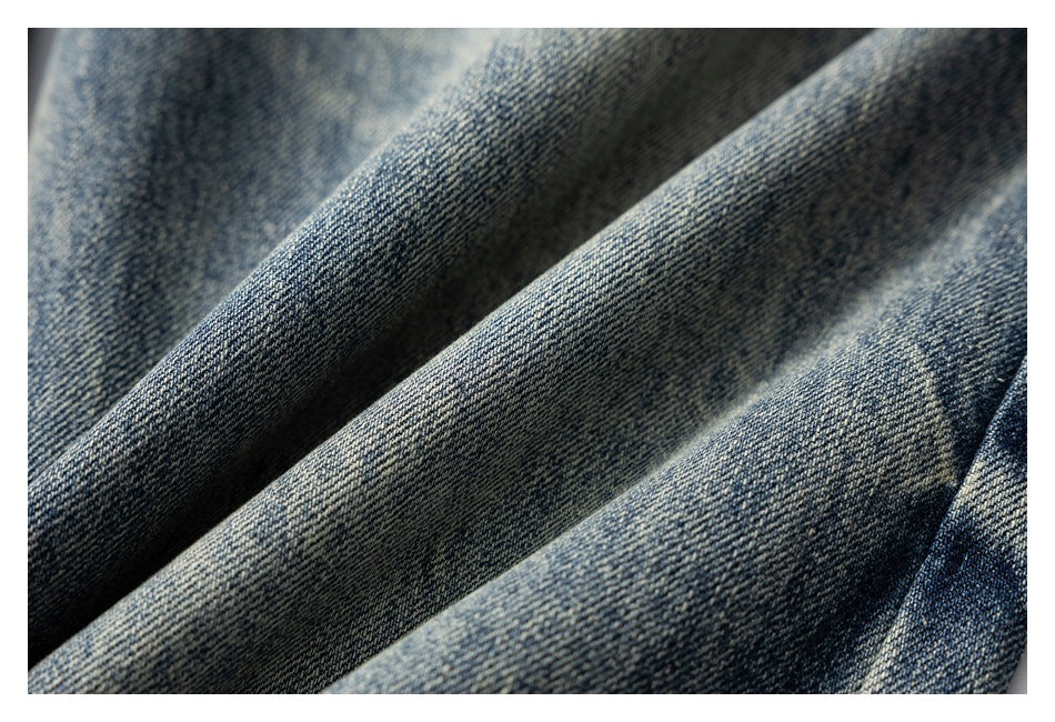 Macro view of blue denim fabric with diagonal twill texture and faded areas.