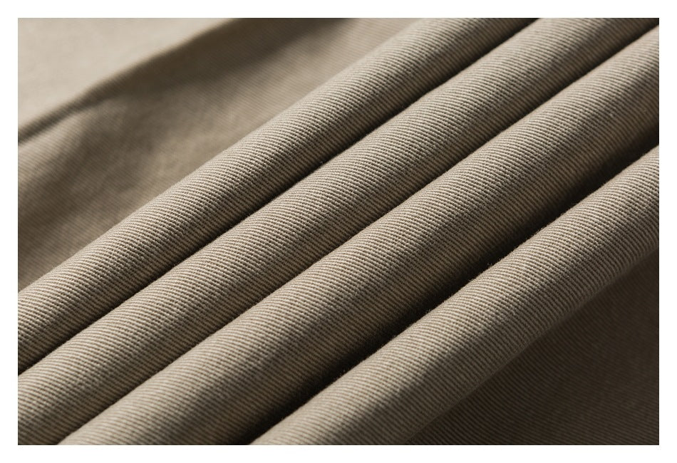 Macro view of beige twill fabric arranged in soft folds, showing its diagonal weave.