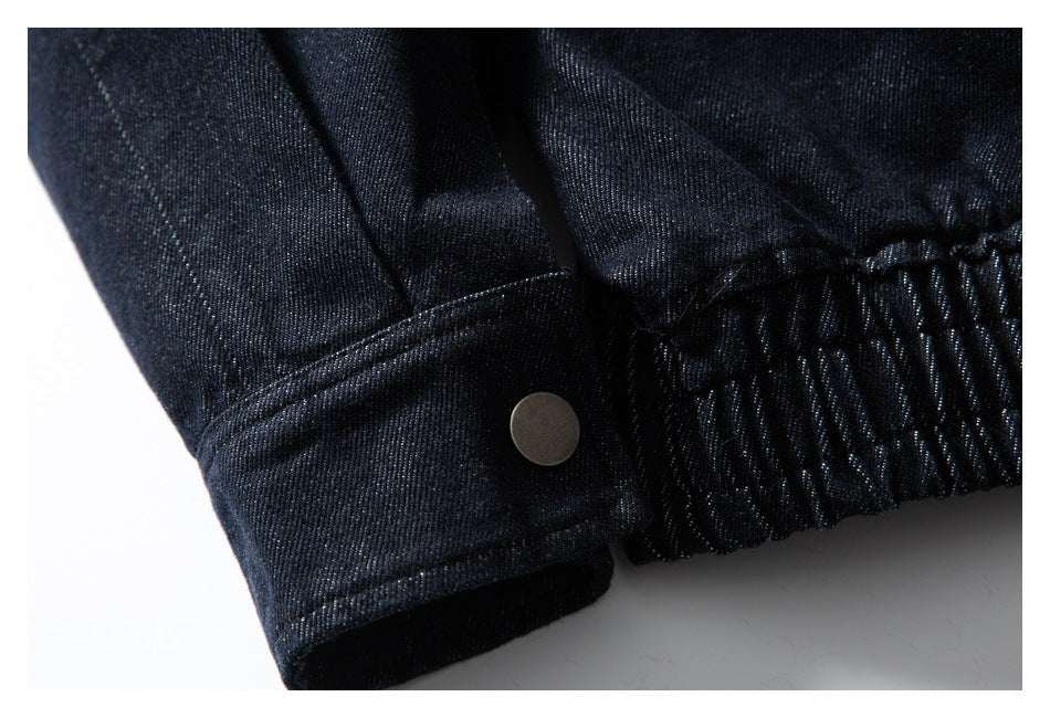 Close-up of dark indigo denim showing a cuff with a round metal snap beside a gathered elastic waistband.