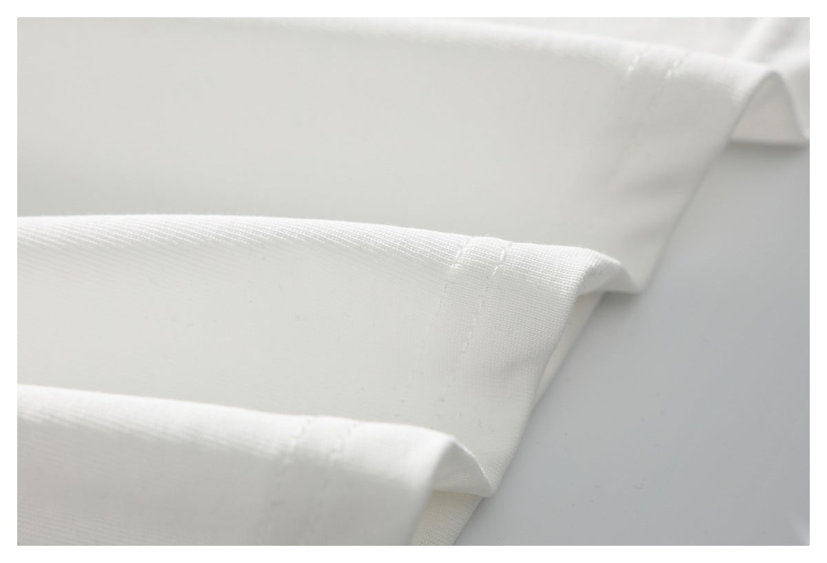Close-up of folded white garment hems with neat stitching.
