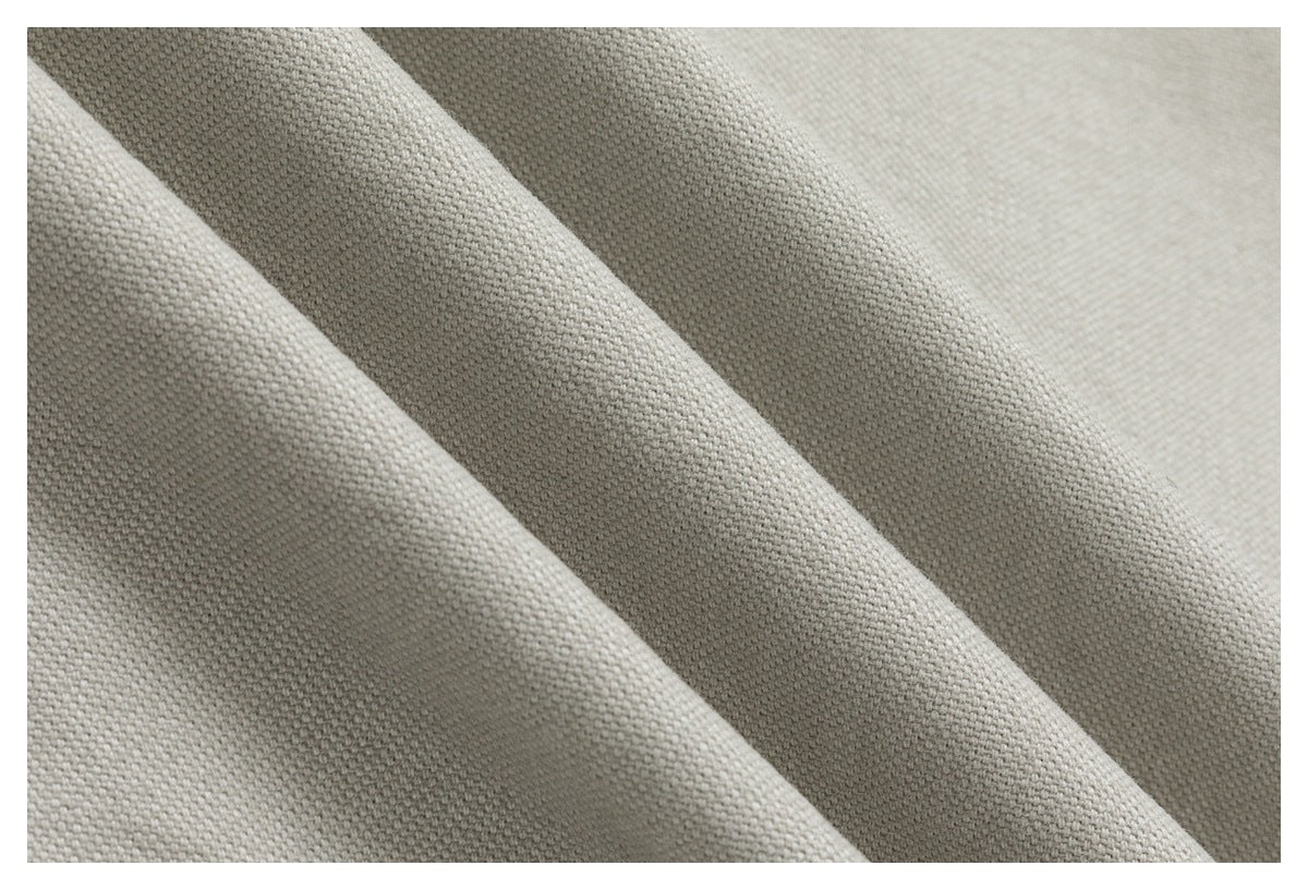 Close-up of light beige fabric showing its textured woven surface and folds.