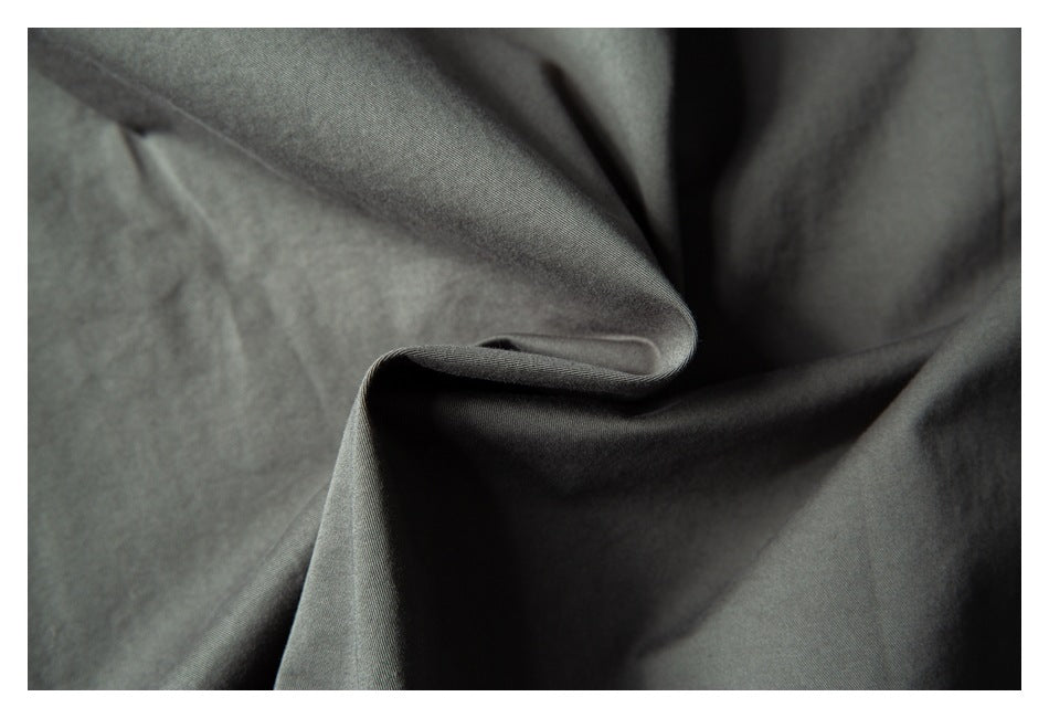 Macro view of charcoal-gray fabric gathered into soft folds.