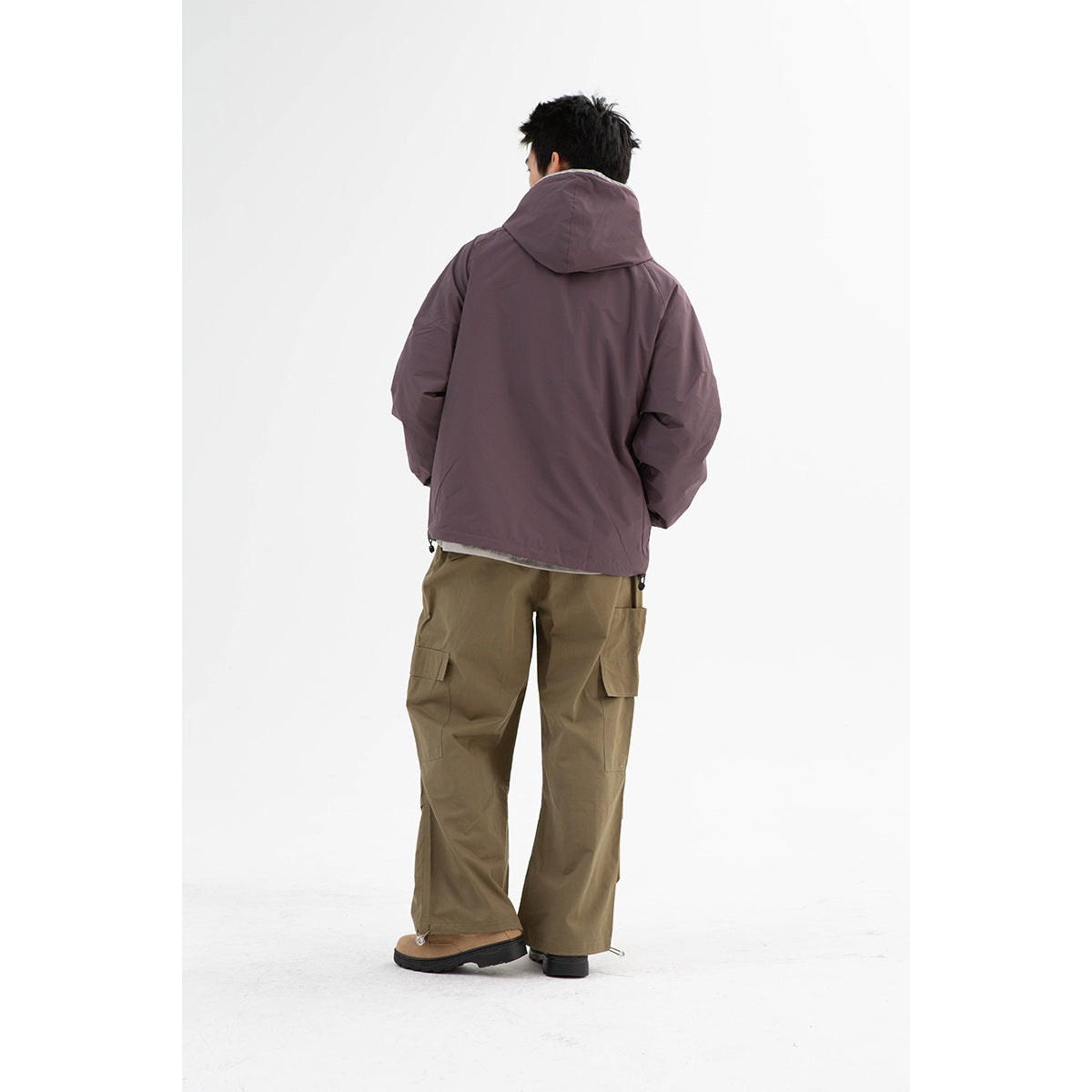 Back view of a model wearing a plum hooded jacket and olive cargo pants.