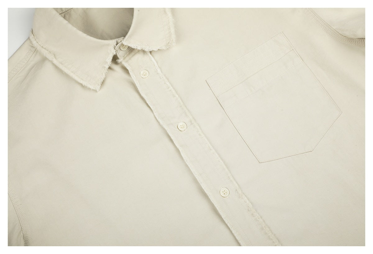 Close-up of the ivory shirt’s frayed button placket and pointed chest pocket.